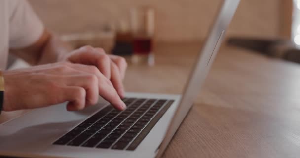 Primeros planos manos masculinas escribir texto en el ordenador portátil PC en la cafetería — Vídeo de stock