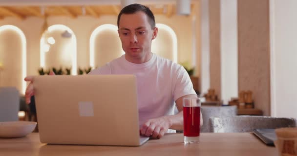 Frilansare man arbetar med bärbar dator i café — Stockvideo
