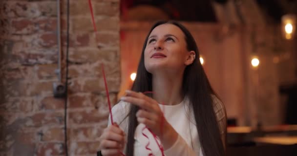 Милая красивая женщина играет с воздушным шаром в кафе — стоковое видео