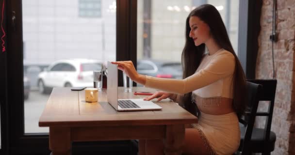 フリーランスの女性はカフェでラップトップPCによって動作します — ストック動画
