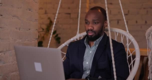 Bir dizüstü bilgisayara bakarken şok geçiren Afrikalı bir adam — Stok video