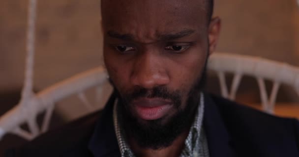 Концентрированный африканский бизнесмен работает на ноутбуке PC в кафе — стоковое видео