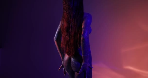 Сексуальная женщина с голубыми блестками позирует в студии — стоковое видео