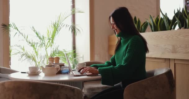 フリーランスの女性はカフェでラップトップPCによって動作します — ストック動画