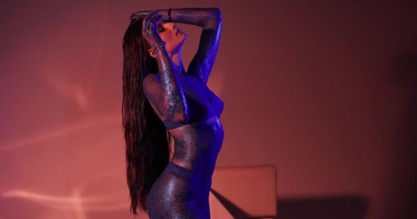 Frau mit blauem Glitzer am Körper posiert im Atelier — Stockvideo