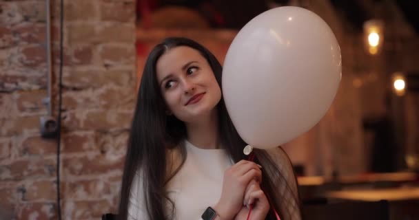 Schattige mooie vrouw speelt met ballon in cafe — Stockvideo