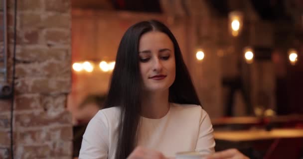 Frau mit Genuss trinkt Kaffee im Café — Stockvideo
