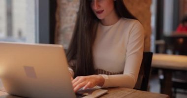 Serbest çalışan kadın kafede bilgisayar başında çalışıyor.