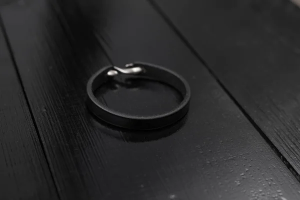 Pulseira masculina de couro preto em uma mesa escura — Fotografia de Stock