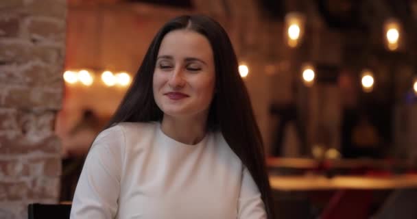 Glad blyg kvinna skrattar i caféet — Stockvideo