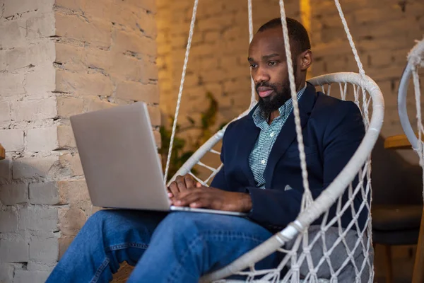 Afrikanischer Geschäftsmann ruht mit Laptop in Café — Stockfoto