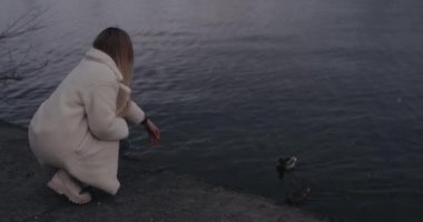 Nehirde ördek besleyen kadın