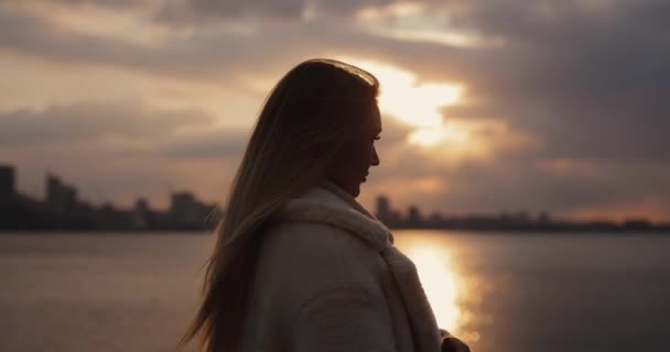 Silueta de cámara lenta de la mujer contra el fondo de la ciudad y el cielo — Vídeos de Stock