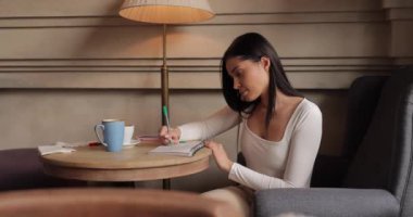 Not defterine notlar yazan kadın