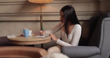 Not defterine notlar yazan kadın