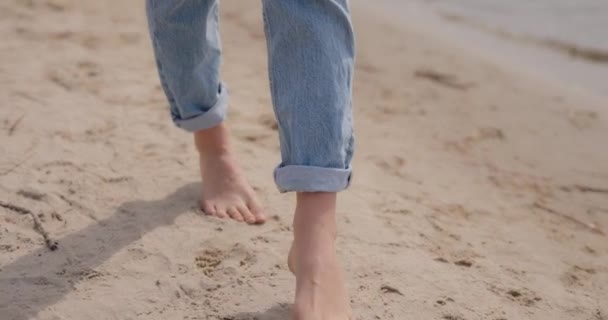 Weibliche Beine barfuß auf Sand — Stockvideo