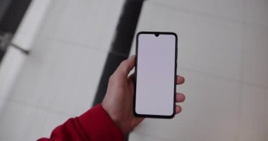 Alışveriş merkezinde boş akıllı telefon ekranı kullanan bir erkek.