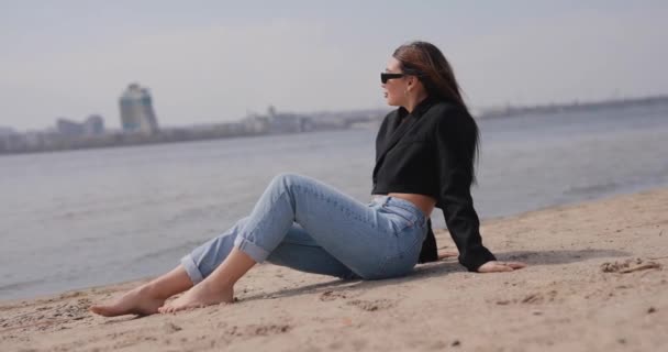 Vrouw die op het strand zit en ontspant — Stockvideo