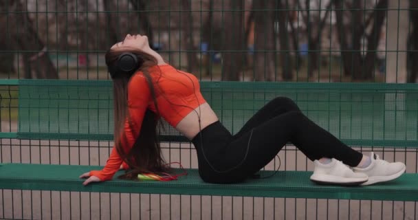 Sportos nő zenét hallgat a fejhallgató szabadban — Stock videók