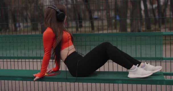 Sportos nő zenét hallgat a fejhallgató szabadban — Stock videók