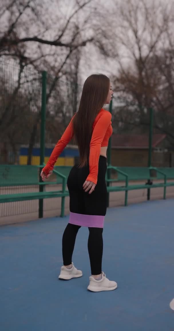 Αθλητική γυναίκα προπόνηση πόδια με λαστιχένιες ταινίες γυμναστικής, κάθετη βίντεο — Αρχείο Βίντεο