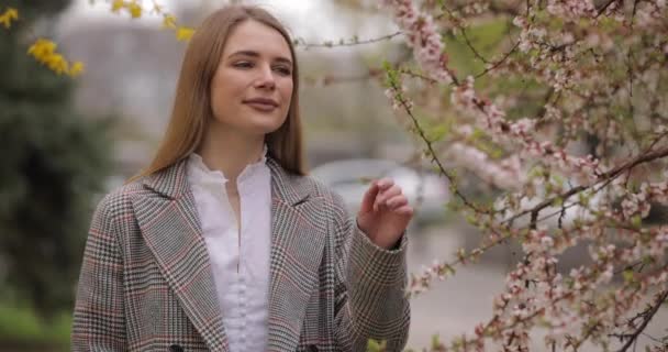 Kobieta wącha zapach pięknego drzewa kwiatowego — Wideo stockowe