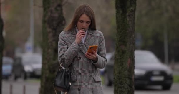 Woman smoke electronic cigarette walking in city — Stock Video
