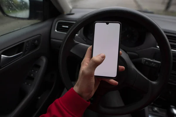Male hand using empty screen of smartphone in a car