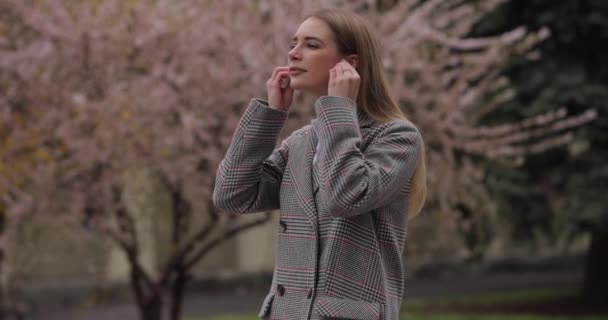 Kobieta zakłada bezprzewodowe słuchawki w zwolnionym tempie — Wideo stockowe