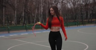 Parkta ip taşıyan seksi bir kadın.