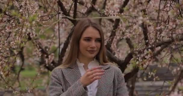 Retrato de mujer cerca del árbol de flores — Vídeo de stock