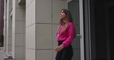 Sporty woman jogger leaving the building and wearing earphones