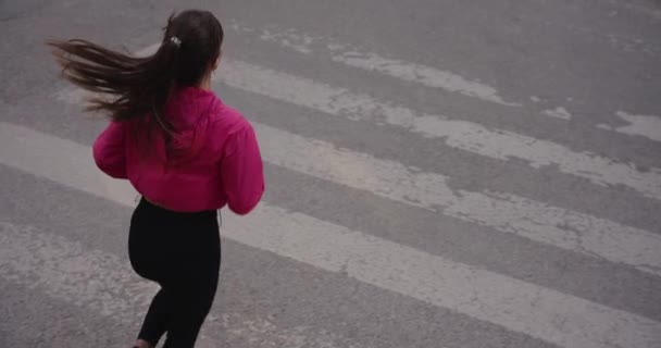 Sporty woman jogging in the city crossing road on a zabra — Stockvideo
