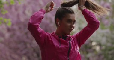 Sportif kadın parkta at kuyruğu yapıyor.