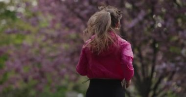 Back view woman jogging in the summer park slow motion