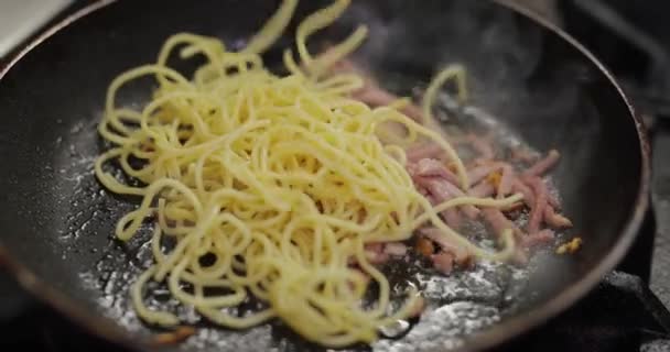 Faire frire la viande avec des pâtes dans une poêle — Video