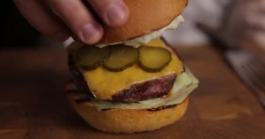 Şef hamburgeri hazırlıyor.