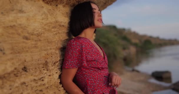 Ładna Kobieta Letniej Sukience Pobliżu Dużego Kamienia Plaży Patrząc Coquettish — Wideo stockowe