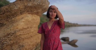 Kadınlık ve çekicilik, yaz elbisesi içinde kumsalda yürüyen güzel bir kadın, ağır çekim.