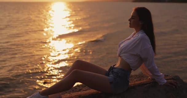 Mujer Joven Mira Atardecer Del Mar Sentado Una Colina Cámara — Vídeos de Stock