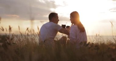 Lovers drink on brotherhood coffee and kisses at sunset