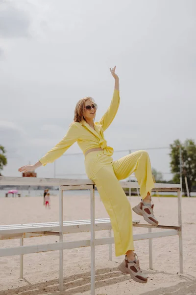 Onnellinen Nuori Nainen Keltaisissa Vaatteissa Rannalla — kuvapankkivalokuva