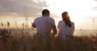 Gün batımında kakao içen çift doğada oturuyor.