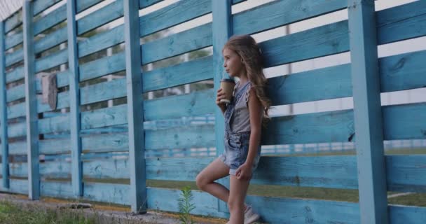 Cute Little Girl Drinking Takeaway Coffee Standing Fence — Stockvideo