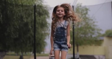 Little girl jumping on a trampoline, slow motion