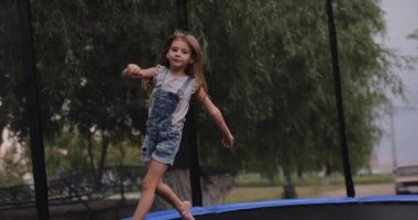 Little girl jumping on a trampoline, slow motion