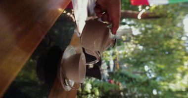 POV man pouring and drinking tea in restaurant, vertical video