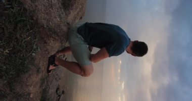 Dramatic sky, man looking at the clouds thinking about future of his life, vertical video