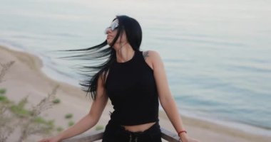 Brunette woman, elegant lady tossing hair near the sea