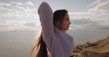 Slow Motion, güzel kadın uzun saçlarına dokunuyor harika deniz ve gökyüzünün üzerindeki tepenin üstünde duruyor